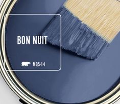 a blue paint can with a yellow brush in it and the words bon nutt