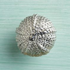 a silver object sitting on top of a wooden table next to a green wall and floor