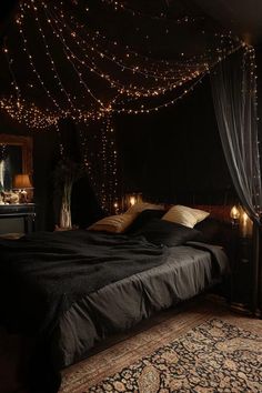 a bedroom with lights strung from the ceiling and a large bed in front of it