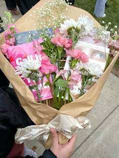 a person holding a bouquet of flowers on the sidewalk