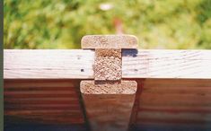 the corner of a wooden bench with a piece of wood sticking out of it