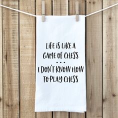 a tea towel hanging on a clothes line that says life is like a game of chess i don't know how to play chess