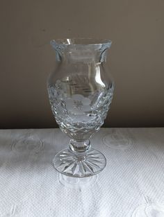 a clear glass vase sitting on top of a white tablecloth covered table with circles around it