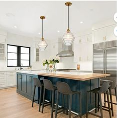 a kitchen with an island and three stools in front of the countertop area