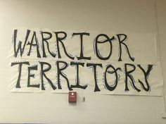 a sign that says warrior territory hanging on the wall