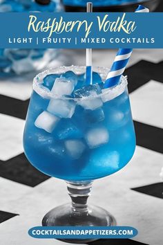 a blue drink in a glass with ice cubes on the rim and a straw sticking out of it