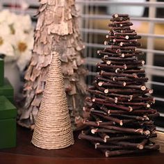 two small christmas trees sitting on top of a wooden table