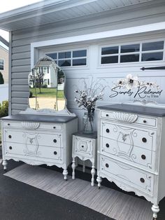 two white dressers and a mirror in front of a house