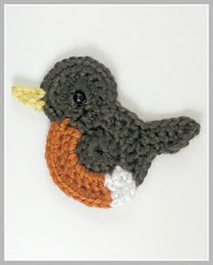 a crocheted bird with an orange beak