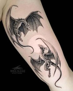 a black and white dragon tattoo on the arm