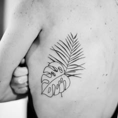 a black and white photo of a woman's stomach with a tattoo on it