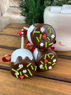 three chocolate covered donuts sitting on top of a wooden table