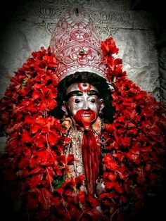 a man with painted face and red flowers around him