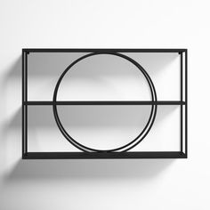 a black metal shelf with a circular object on it's side, against a white wall