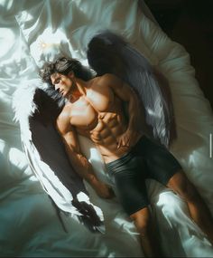 a man laying on top of a bed next to an angel