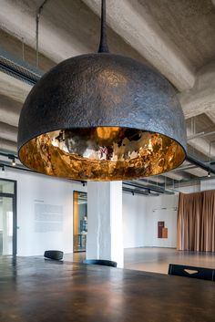 an empty room with a large round light fixture hanging from the ceiling