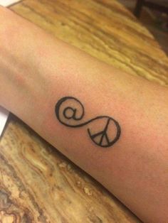 a person's arm with a peace sign tattoo on the left side of their arm