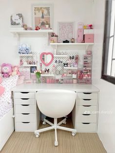 a white desk topped with lots of drawers next to a wall filled with pictures and toys