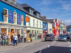 a group of people standing in front of a store on the side of a road