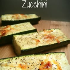 zucchini with cheese and seasoning on it sitting on a wooden cutting board