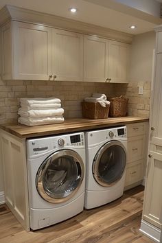 a washer and dryer in a room with white cabinets on either side of the washer