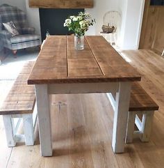 a wooden table with two benches in front of it and a vase filled with flowers