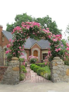 a house with pink flowers on the front gate