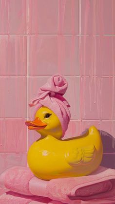 a yellow rubber duck with a pink towel on it's head