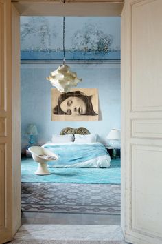 an open door leading to a bedroom with a painting on the wall and bed in it