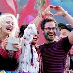 a group of people standing next to each other with their hands up in the air