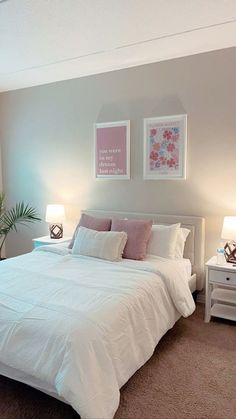 a white bed sitting in a bedroom next to two lamps on either side of the bed