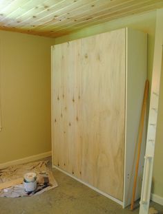 an unfinished room with wood paneling on the walls