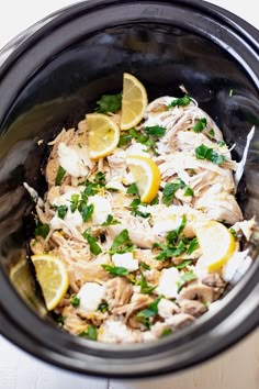 a crock pot filled with chicken and lemons