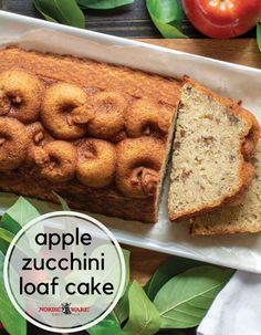 an apple zucchini loaf cake on a plate with leaves and apples in the background