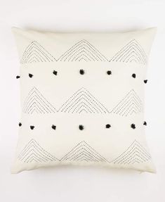 a white pillow with black dots on it