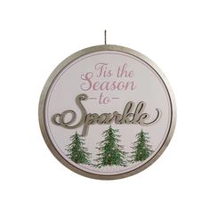 a sign that says tis the season to sparkle with pine trees in the background and lettering on it