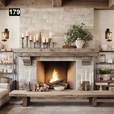 a living room with a fire place in the middle and candles on the fireplace mantel