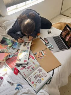 a person sitting on a bed with many pictures and laptops