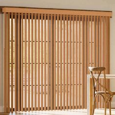 a dining room with wooden slats and chairs in front of the sliding glass door