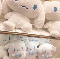 several white stuffed animals are on display in a store, with blue eyes and ears