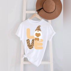 a white t - shirt with leopard print on it and a brown hat hanging from a ladder