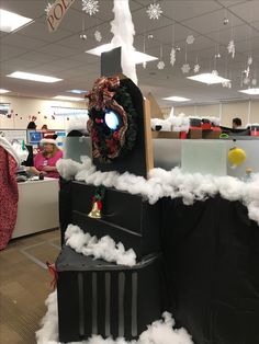 an office cubicle decorated for christmas with fake snow and decorations on the desks