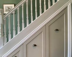 a white stair case next to a green wall