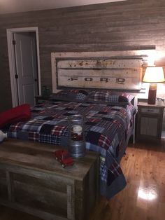 a bed room with a neatly made bed and a night stand on the side table