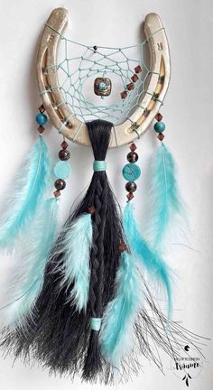 a dream catcher with feathers and beads hanging on the wall