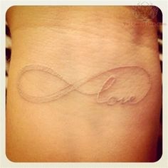 a woman's wrist tattoo with an infinite symbol on the left side of her arm