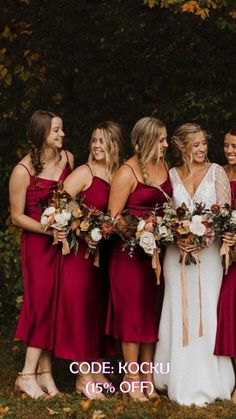 a group of women standing next to each other wearing red dresses and holding bouquets