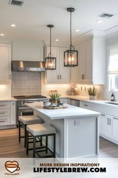 a large kitchen with white cabinets and an island in the center is lit by pendant lights