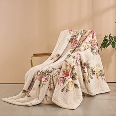 a chair with a blanket on it next to a potted plant