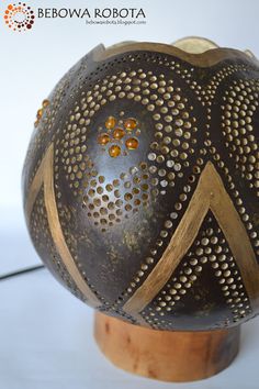 a brown and gold vase sitting on top of a wooden stand